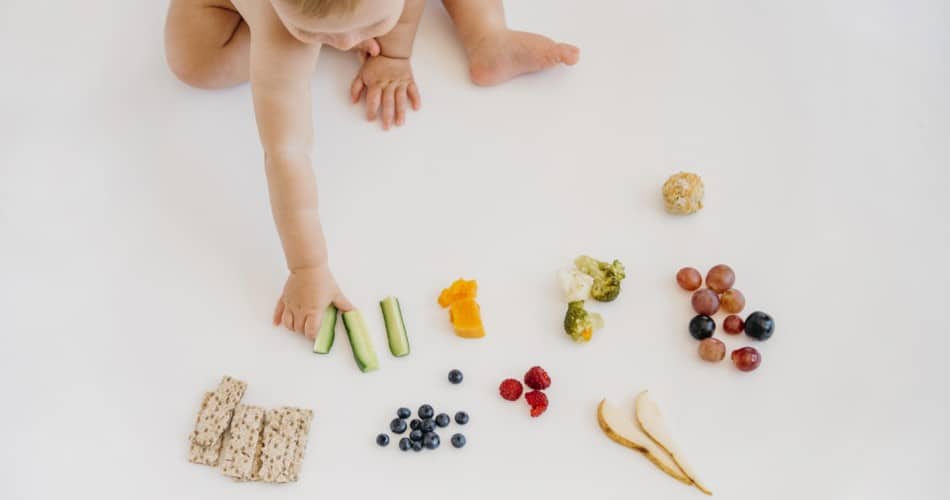 Baby greift nach fürs Baby geeignete Lebensmittel.