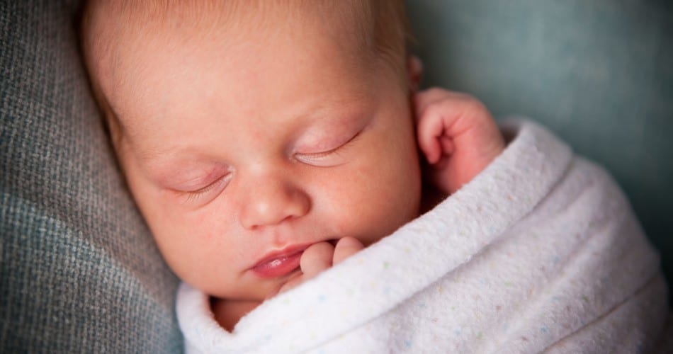 Ein gepucktes Baby – Titelbild zu Beitrag über das Thema, ob Pucken schädlich für Babys ist.