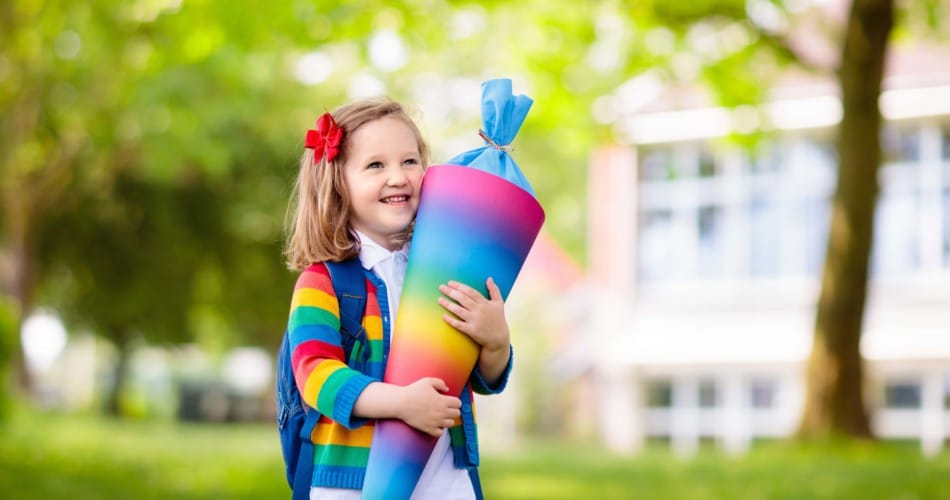 Ein Mädchen hält eine bunte Schultüte, die mit kreativen Ideen gefüllt ist.
