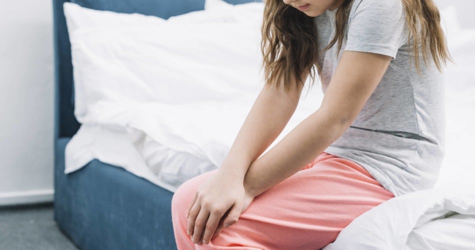 Ein Mädchen hat Schmerzen im Knie