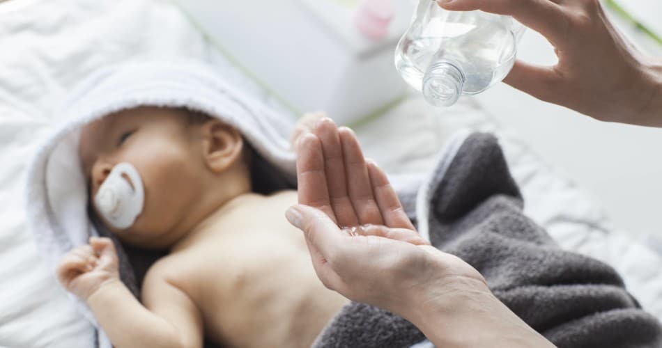 Eine Mutter ist dabei, ihr Baby mit einem ätherischen Öl einzureiben.