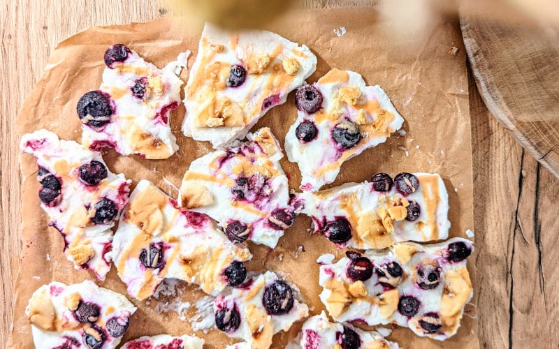 Frozen Yogurt Bars serviert auf Backpapier und in Stücke gebrochen