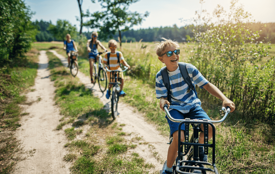 Familie macht bei bestem Wetter einen gemeinsamen Fahrradausflug in der Natur.